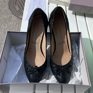 Klackskor - Super söta svarta klackskor med spetsig tå & rosett  från 5th Avenue. Storlek 37