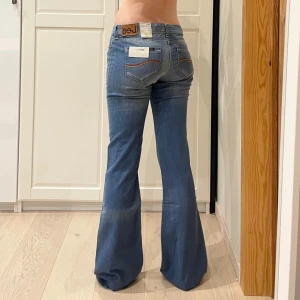 Lågmidjade bootcut jeans från Lee🤩 - Nya med lappen kvar!! Midja 41 cm rakt över, gren 21 cm o innerben 85 cm💕Jae 169 o xs-s för referens och de är för långa. Obs missfärgad rand längst grenen bak och en tvärs över ena benet som uppstått under produktionen. Se bilder