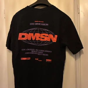 Svart t-shirt med tryck - Svart t-shirt med stort tryck på ryggen. T-shirten har rund hals och lite större passform. Perfekt för dig som gillar streetwear.