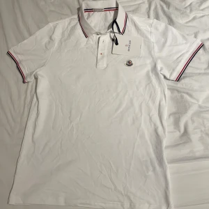 Vit pikétröja Moncler - Säljer en klassisk vit pikétröja från Moncler. Den är i 10/10 skick. Aldrig använd och helt ny. 