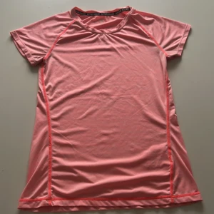 Rosa sport t-shirt från H&M Active Squad - Säljer en rosa sport t-shirt från H&M Active Squad. T-shirten har korta ärmar, rund halsringning och är tillverkad i ett lätt och stretchigt syntetmaterial som passar perfekt för träning. Den säljs eftersom den inte används längre. Det finns några tecken på användning, som trådar som har gått upp🩷