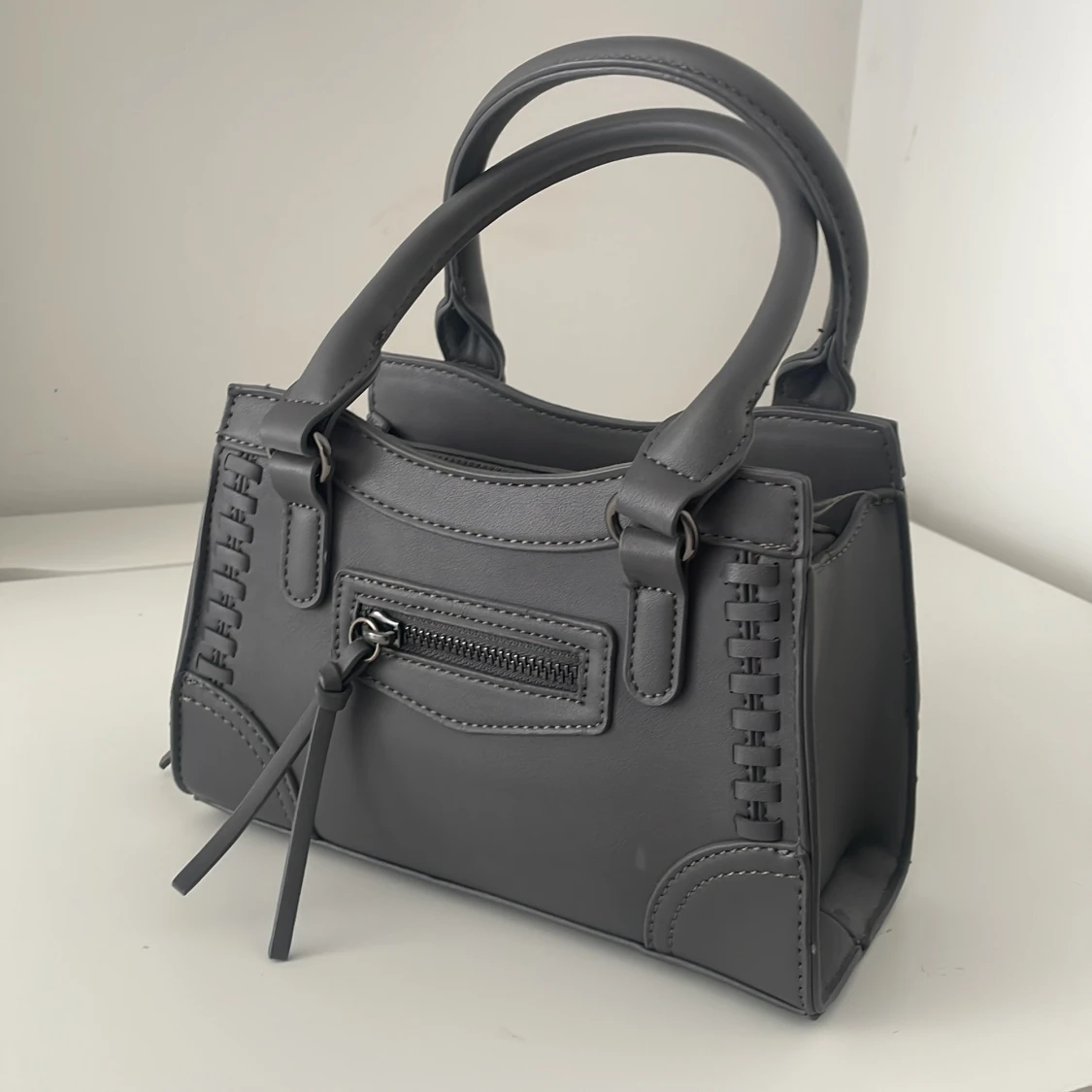 Grå handväska med dragkedjedetalj