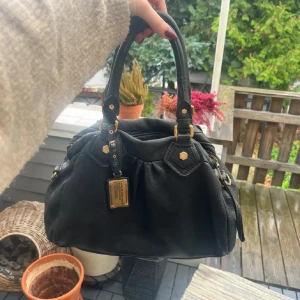 Marc jacobs väska - Säljer min Marc by Marc Jacobs handväska som är i bra skick, små slitningar som ni kan se på bilden till exempel lite sliten i lädret och på handtaget men det är inget som man lägger märket till, och lite smutsig insida. Längre band och påsen tillkommer. Köp via köp nu funktionen ❣️köp direkt för 2000