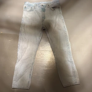 Ljusblå Levis 501 jeans - Säljer ett par klassiska ljusblå Levis 501 jeans. De har en rak passform och är tillverkade i jeansmaterial. Perfekta för en avslappnad stil.