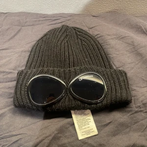 Svart ribbad CP Compnany mössa  - Snygg svart CP Company mössa. Mössan är köpt på Farfetch och i bra skick. Har ni frågor angående pris eller annat är det bara att skriva :)