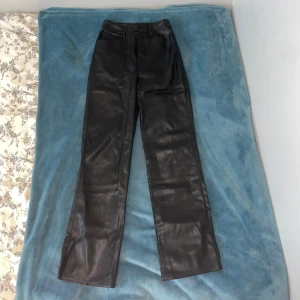svarta faux läderbyxor bikbok - svarta byxor i konstgjord läder från bikbok (de såg typ bruna ut på bilderna, men de är svarta). ca 30-31 cm tvärsöver midjan. 101 cm från högst upp till längst ner. en stråd från knappen har lossnat så den sitter fast men den sitter löst (se sista bild). har själv fållat upp dem. skriv för frågor eller mer mått! :)