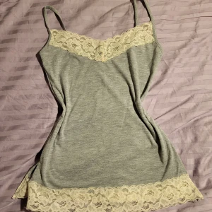 Linne med spetsdetaljer från Gina Tricot - Jättefint grått linne från gina tricot i storlek S med vita spetsdetaljer. 