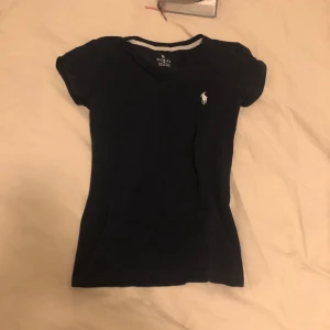 Topp - Snygg Marinblå t-shirt med korta ärmar och klassisk passform. 