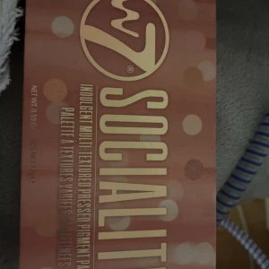 Socialite ögonskuggspalett från W7 - Snygg ögonskuggspalett från W7 med namnet Socialite. Innehåller flera nyanser i både matta och skimrande texturer. Perfekt för att skapa olika looker med en mix av neutrala och glittriga färger.