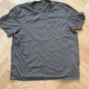 Maringrön t shirt - En enkel och stilren grå t-shirt med korta ärmar. Perfekt för en avslappnad look.