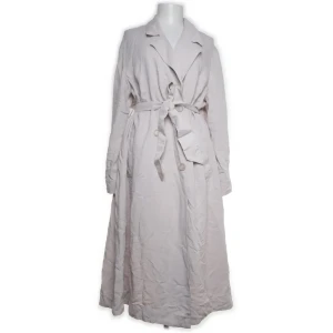 Beige trenchcoat med bälte - Snygg beige trenchcoat med knytbälte i midjan och knappar framtill. Långärmad design med klassisk krage och slits baktill. Perfekt för en stilren look. Köpt på Sellpy för 200kr 💕💕