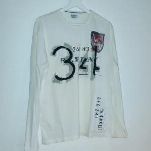 Vit långärmad tröja från Replay - Säljer en vit långärmad tröja från Replay med tryck i svart och grått på framsidan. Tröjan har en avslappnad passform och är perfekt för en casual look. Den är tillverkad i ett mjukt material som känns skönt mot huden.