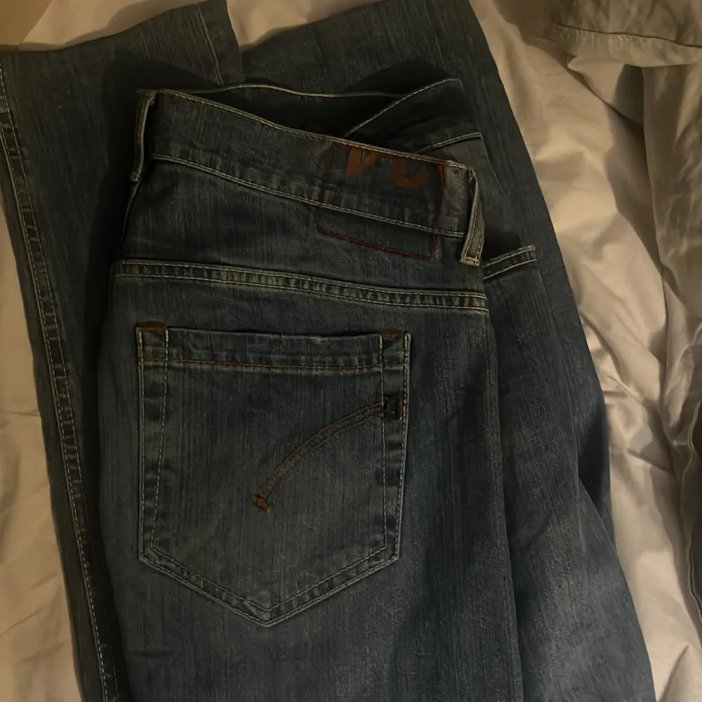 Snygga blå jeans från Dondup med en klassisk femficksdesign. De har en lätt tvättad look och stängs med knappar. Skick 9/10. Sitter slim fit, säljer pga av att de är för korta för mig.. Farkut & Housut.