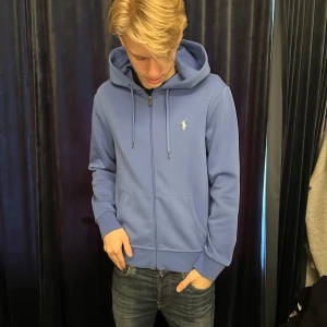 Blå zip hoodie från Ralph Lauren - Säljer en skön raffe zip, helt ny aldrig använd förutom vid tagning av bilderna. Storlek S, nypris 1500 kr. Mitt pris 699! Skriv vid frågor eller funderingar. 