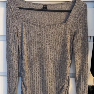 Grå ribbad tröja  - Säljer en stilren grå ribbad tröja. Tröjan har en v-ringad hals och långa ärmar, perfekt för en avslappnad look. Passar bra till både jeans och kjol. Hör av dig vid intresse! 😊