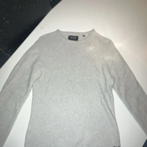 Grå stickad tröja från Only & Sons skön och stretchig - Säljer en stilren grå stickad tröja från Only & Sons. Perfekt för kyligare dagar med sin mjuka och bekväma passform. Tröjan har långa ärmar och en rund halsringning.