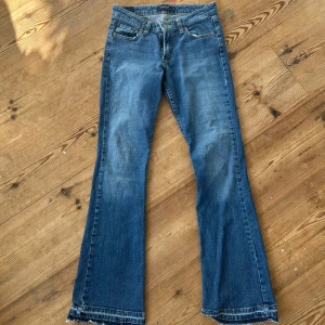 Blå bootcut jeans från Levi's - Lågmidjade Levis jeans med bootcut. Modellen är superlow 518 och de har super snygga fickor och slitna detaljer vid fållen⭐️ midjemåttet är 37cm och innerbenslängden är 80cm