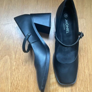 Svarta Mary Jane skor från Monki - Snygga svarta Mary Jane skor från Monki i veganskt material. De har en fyrkantig tå och en bred klack för en klassisk look. Jag har inte använt skorna mycket och det är därför i mycket bra skick. Skorna är perfekta för bröllop eller studenten osv🥰 Priset kan diskuteras💞