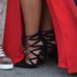 Svarta klackskor med snörning - Eleganta svarta klackskor med spetsig tå och snörning som går upp längs vristen. Skorna har en hög klack och är tillverkade i ett material som liknar mocka. Klackarna har skavanker men är användbara och fina.