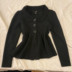Svart kavaj från H&M - Snygg svart kavaj från H&M med stora knappar framtill och en elegant krage. Jackan har en figursydd passform och långa ärmar, perfekt för en stilren look. 🖤 känns som storlek. S eller M. Hör av er vid frågor💗