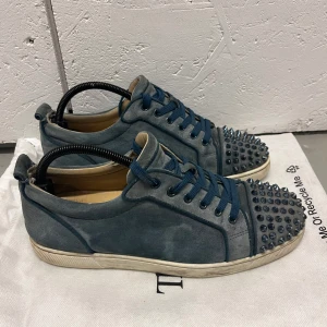 Christian Loubotin sneakers babyblue - Hej! Säljer nu dessa Christian Louboutin skorna i en väldigt snygg och eftertraktad färg. Skicket på skorna är 8/10 (två nitar saknas) dock har mockan precis blivit rengjord. Storlek 41 men passar även större😊