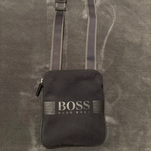 Hugo Boss axelväska  - Säljer denna Hugo Boss axelväska, bra skick, går att diskutera priset vid en snabb och enkel affär. Tveka inte på att höra av dig vid minsta lilla fråga!🤩
