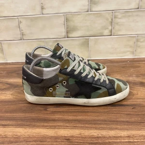 Golden Goose Sneakers Camouflage - Golden Goose Skor | Skicket är 9.5/10 - Storlek 42 (passar 43 EU) Nypris 5499kr - Vårat Pris: 2399, skorna är i otroligt bra skick , inga som helst tecken på användning! Tveka inte vid att ställa frågor vid funderingar. Priset kan självklart diskuteras! 