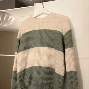 Randig tjocktröja  - Varm och fin stickad tjocktröja som är använd en gång. Grön och vit. Hör av er vid funderingar eller om ni vill ha bilder med hur plagget sitter på mig.