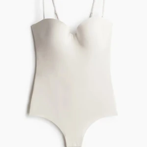 Body - Säljer en helt ny vit/beige body från hm som är helt slutsåld. Den är i 85 C och har prislapp och allt kvar. Kan ta av och på axelbanden. Mjukt och trevligt material, skriv om du har några frågor🥰