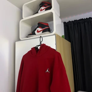 Röd hoodie från Jordan och ett par Jordan skor  - Säljer en snygg röd outfit från Jordan med det ikoniska logotypen på bröstet. Perfekt för en sportig look eller bara för att chilla. Den har en klassisk passform och är gjord i ett mjukt material för extra komfort. Skorna är storlek 44