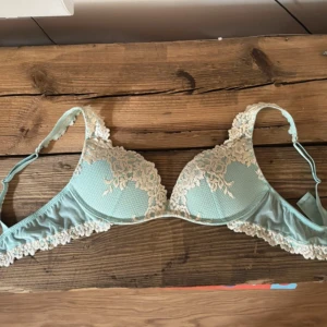 Limited Ljusblå spets-bh med broderade detaljer - Säljer en ljusblå bh med vacker spets och broderade blommor i vitt. Bh:n har justerbara axelband och fina spetskanter längs kuporna och under bysten. Perfekt för dig som gillar romantiska detaljer.