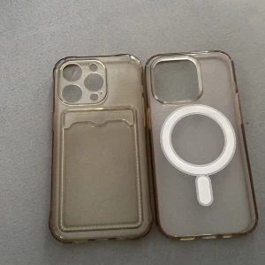 Genomskinliga mobilskal med MagSafe och kortfack - Två genomskinliga mobilskal i beige/transparent plast. Ena skalet har MagSafe-ring och den andra har ett inbyggt kortfack på baksidan. Båda har förstärkta kanter och stora kamerauttag. Perfekt för dig som vill skydda mobilen och ha med korten smidigt. 2 för 100kr !!!