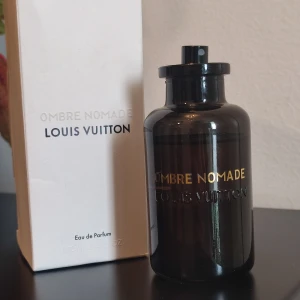Louis Vuitton Ombre Nomade - Louis Vuitton Ombre Nomade, en exklusiv Eau de Parfum. Flaskan på 100 ml, se bilder för mängd som är kvar. Uppskattningsvis 80% kvar. Flaskan har små skönhetsfel, texten fram är lite skrapad, några mindre prickar på flaskans baksida och hals. Sprayern har blivit sned och sprayar endast i det läget. Kanske går att fixa?. Kommer utan kork. Kartong medföljer med matchande batchnummer. Se kartongens skick på bilderna!