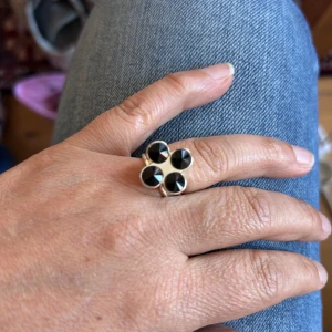 Ioaku ring med svarta stenar - Säljer en  ring med fyra stora, runda svarta stenar.  Perfekt statement-piece för dig som vill sticka ut med dina accessoarer.