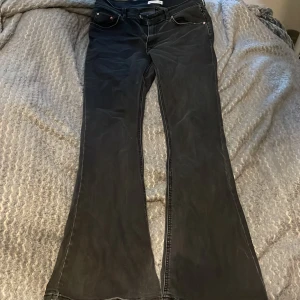 Svarta bootcut jeans från gina tricot - Svarta jeans från gina tricot med klassisk femficksdesign och bootcut-ben. Jeansen har normal passform och är perfekta för dig som gillar en tidlös stil med lite utsvängda ben.