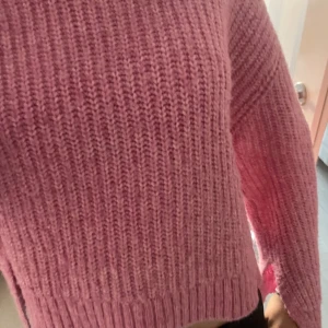 Rosa stickad tröja från Gina Tricot - Säljer en söt rosa stickad tröja från Gina tricot. Tröjan har en rund halsringning och är perfekt för lager-på-lager.