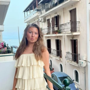 Plisserad volangklänning gul  - Säljer en superfin klänning i ljus gul med flera lager volanger och plisserat tyg. Klänningen har en luftig känsla och är perfekt för sommarens tillfällen.💕💕