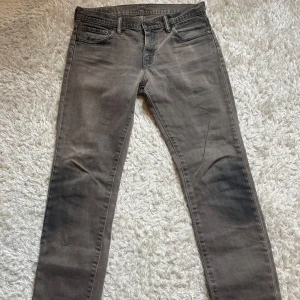 Grå Levi's 511 jeans - Säljer ett par grå Levi's 511 jeans med klassisk femficksdesign och raka ben. Jeansen har normal passform och är tillverkade i ett mjukt denimtyg. Perfekta för dig som gillar stilrena och tidlösa byxor.