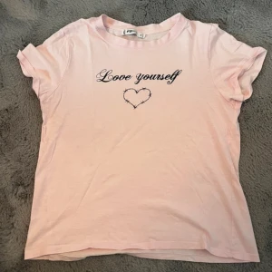 Ljusrosa t-shirt  - Rosa t-shirt med motiv ’love yourself’. Anvönd enstaka gånger!