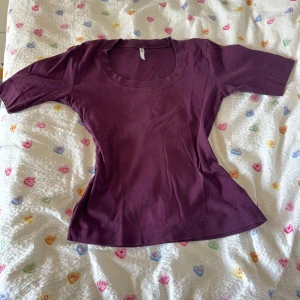  Flash lila topp  - Säljer en mörklila topp från flash med rund halsringning och korta ärmar. Säljer pga kommer inte till användning. 100% bomull. 