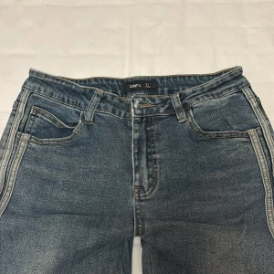  bootcut jeans   - Snygga blå bootcut jeans  ljusa dubbla ränder längs sidorna. Använd fåtals gånger