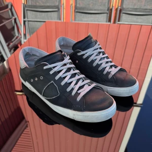 Philippe Model svarta sneakers i skinn - Snygga svarta Philippe Model sneakers i skinn med vita detaljer och snörning, perfekt till nu när hösten smyger på. Skorna är storlek 43 och använda men väl omhändertagna. Original låda följer med om jag hittar den. Tveka inte att ställa frågor 💯