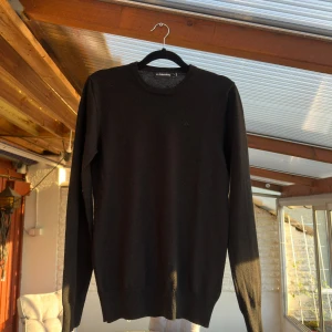 Tunnt stickad J.Lindeberg tröja/crewneck - Svart - Hej! Jag säljer min svarta J.Lindeberg tröja då den blivit för liten för mig. Den är i fantastiskt skick, ser inte ens använd ut. Inga hål, rivmärken eller nopprig överhuvudtaget. Om fler bilder önskas är det bara att fråga på!                              Storlek S, passar troligtvis upp till 175cm i längd, men är ganska smal i passformen.