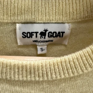 Ljusgul kashmirtröja från Soft Goat - Supermjuk ljusgul tröja i 100% kashmir från Soft Goat. Tröjan har rund hals, långa ärmar och en unik stickad detalj med volangliknande struktur nedtill. Perfekt för dig som vill ha något extra cozy och stilrent i garderoben.
