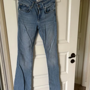 Bootcut jeans i ljusblå denim från 157 - Bootcut jeans i ljusblå denim från 157 med låg midja. Jeansen har klassisk femficksdesign, råa fransiga benslut och en liten slitning på ena benet. Perfekta för dig som gillar en avslappnad och trendig look.