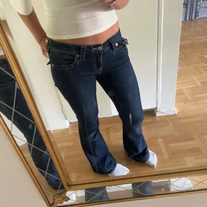 True Religion mörkblå bootcut jeans - Snygga mörkblå jeans från True Religion med låg midja och bootcut. Väldigt fint skick och i storlek 27W 32L