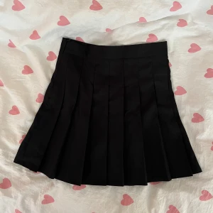 Svart plisserad kjol - En svart plisserad kort kjol från SHEIN i storlek M.   Klassisk skoluniforms-vibe med bred linning och dragkedja vid sidan!💞