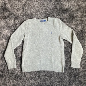 Ralph lauren tröja - Klassisk grå stickad tröja från Polo Ralph lauren. Storleken är L men passar mer som en S-M. Hojta till om du har någon fråga!
