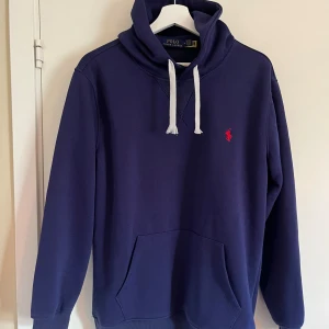 Marinblå hoodie från Polo Ralph Lauren - Sälje min hoodie från Ralph lauren. Bara 2 månader gammal. Köpt i Portugal i maj. Storlek medium. Väldigt bekväm
