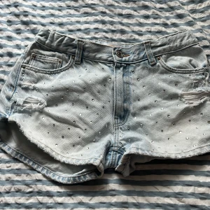 Ljusblå jeansshorts med pärlor  - Snygga ljusblå jeansshorts från Gina Tricot med pärldetaljer. 
